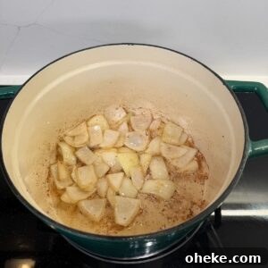 Southern-Style Green Beans and Potatoes Recipe for Comforting Sides 6 Onions cooking in a dutch oven.