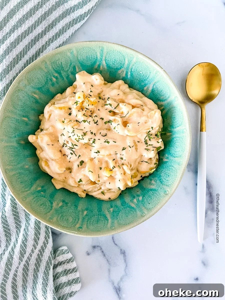 Creamy Slow Cooker Macaroni and Cheese Recipe 3 Serving of cheesy pasta in a green bowl.