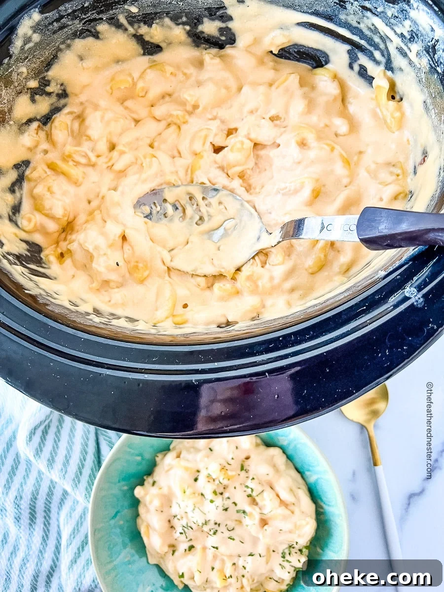 Creamy Slow Cooker Macaroni and Cheese Recipe 7 serving spoon in a pot full of cheesy pasta