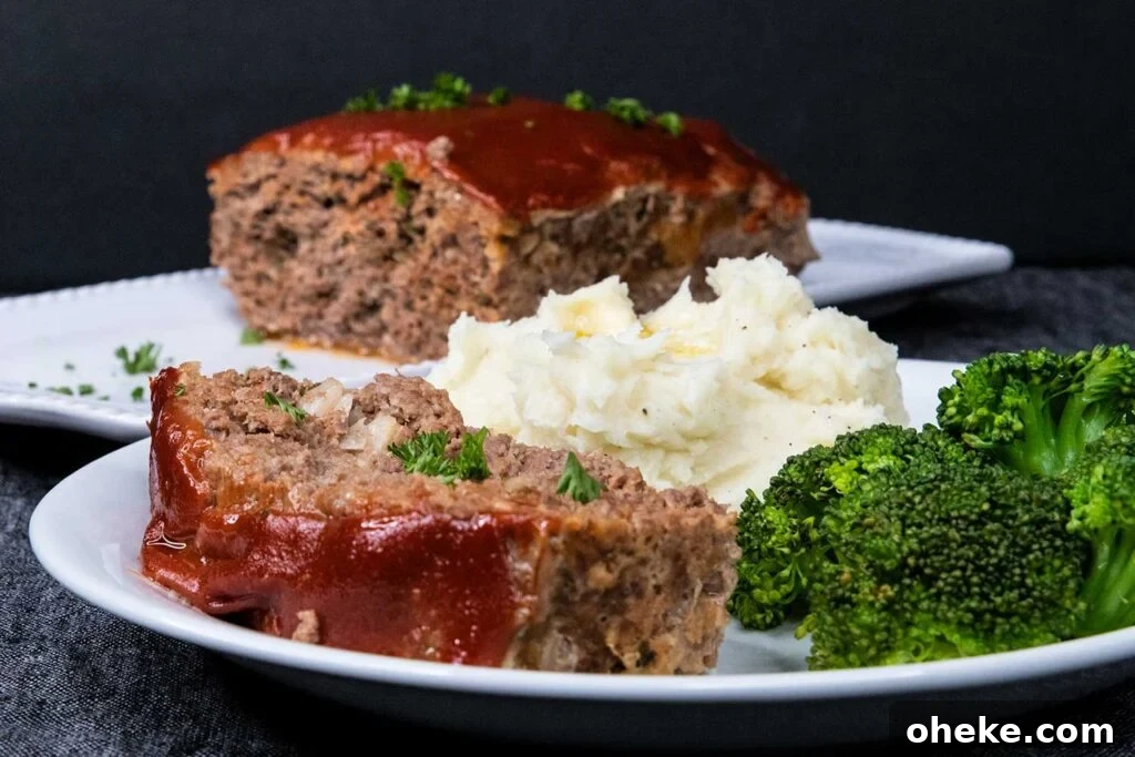 Meatloaf with mashed potatoes and broccoli on a white plate.