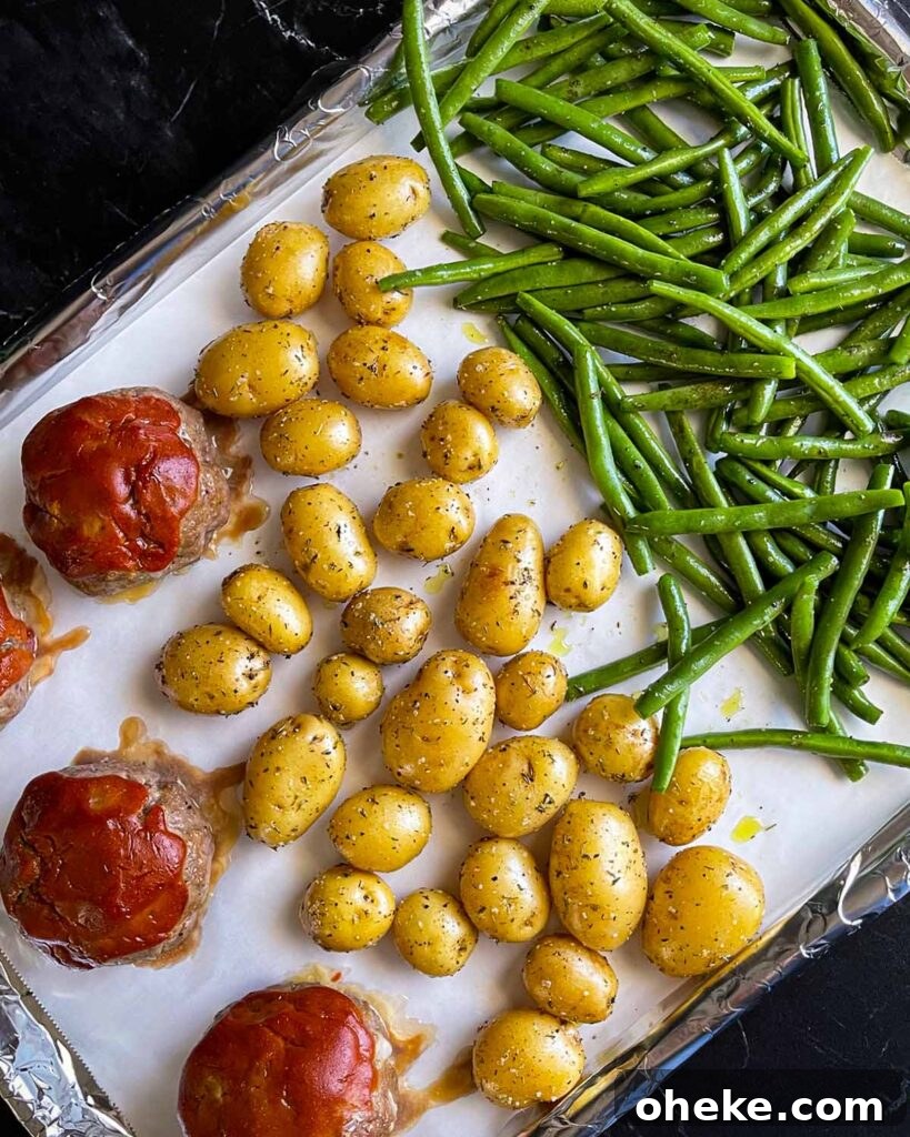 The green beans added to the baking sheet with the mini meatloaves and potatoes.