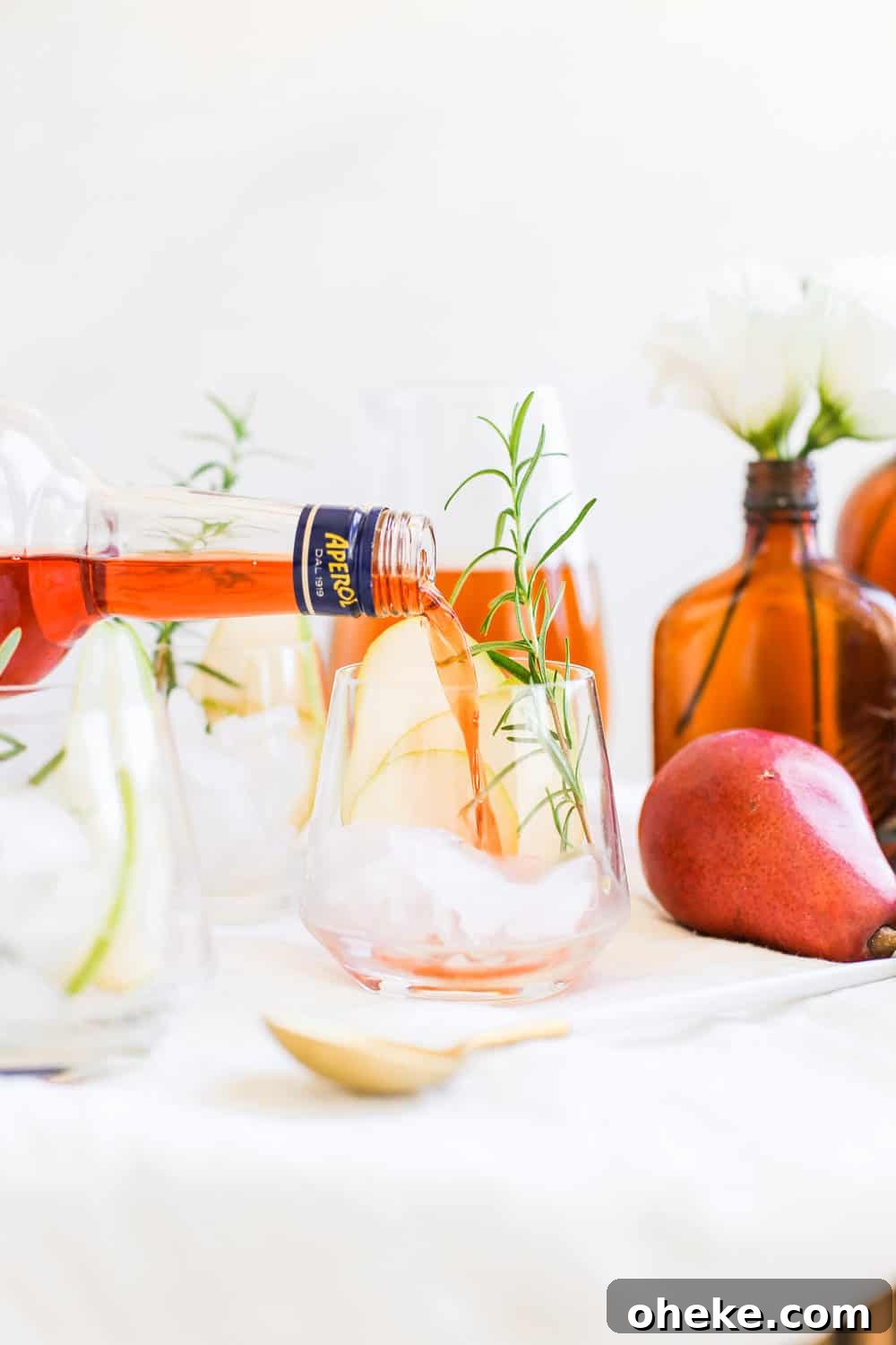 Aperol being poured into a low clear glass.
