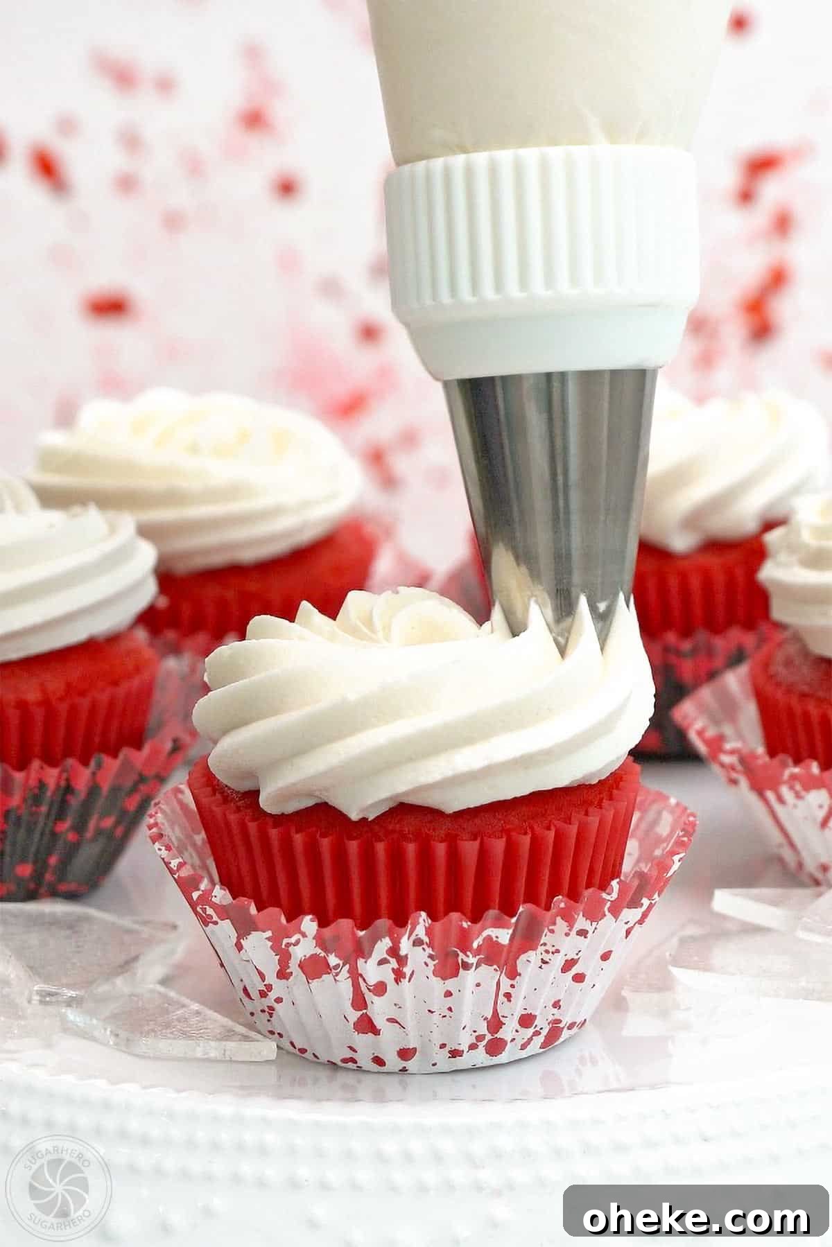Bloody Glass Cupcakes Recipe: Spooky Jello-Filled Treats for Halloween 23 White frosting being piped onto a red velvet cupcake.