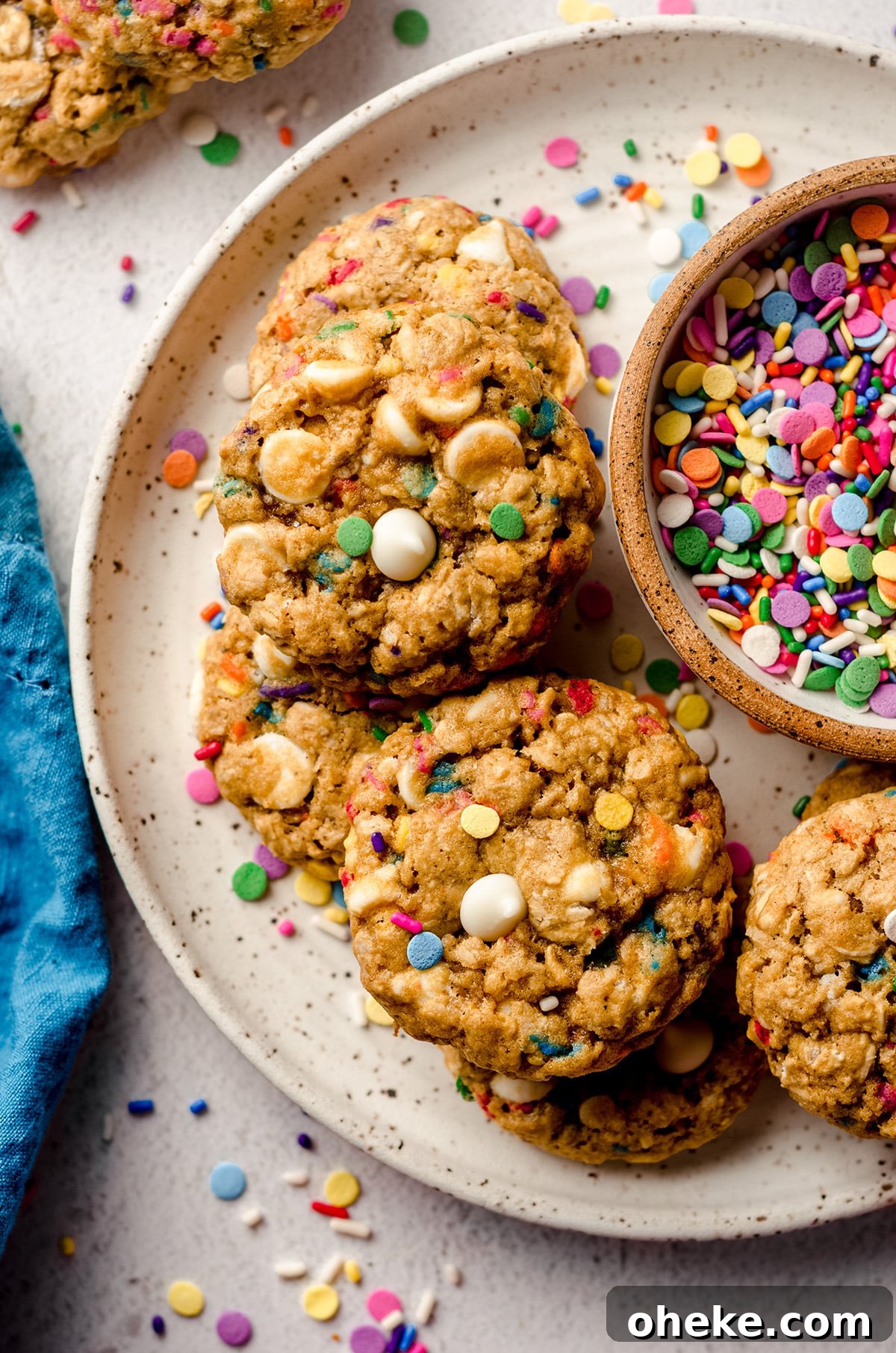 Funfetti White Chocolate Oatmeal Cookies Recipe 5 aerial photo of funfetti oatmeal cookies on a plate with a bowl of sprinkles