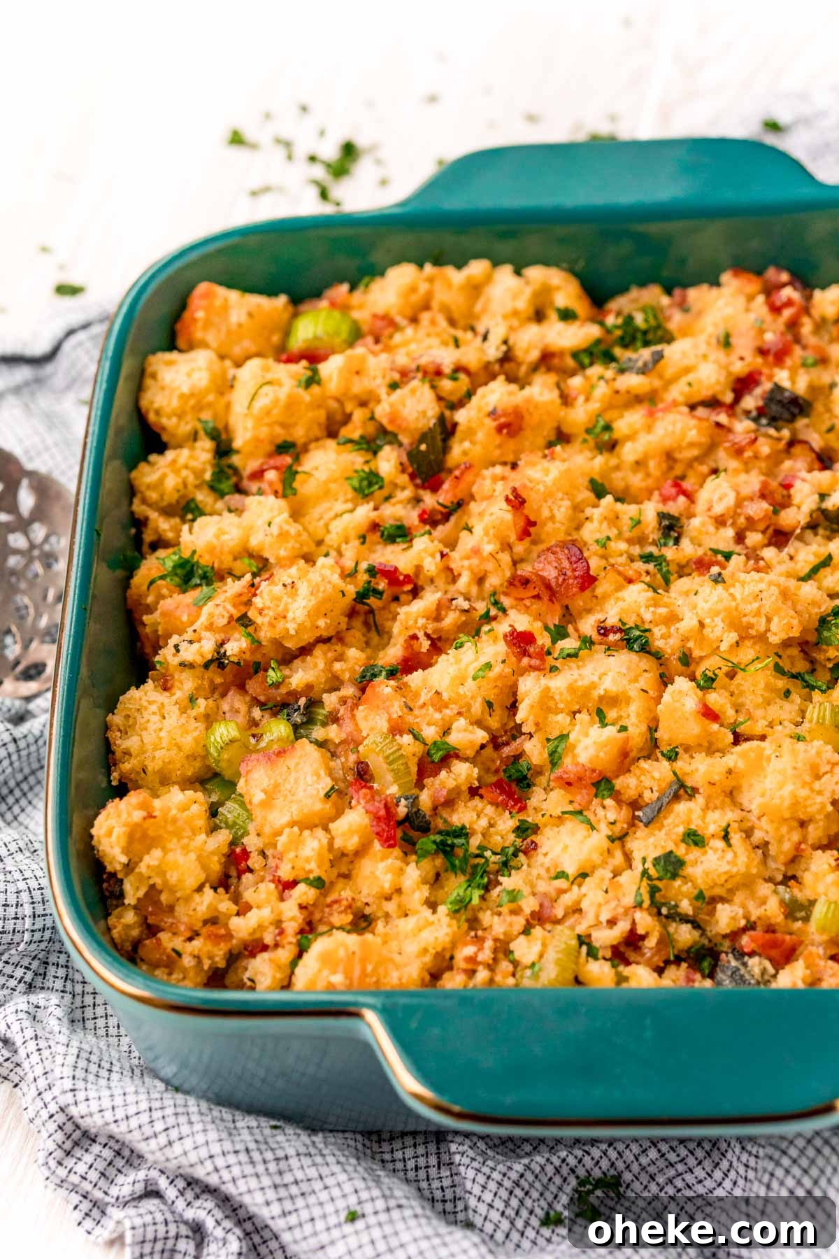 Cornbread dressing in a teal baking dish.
