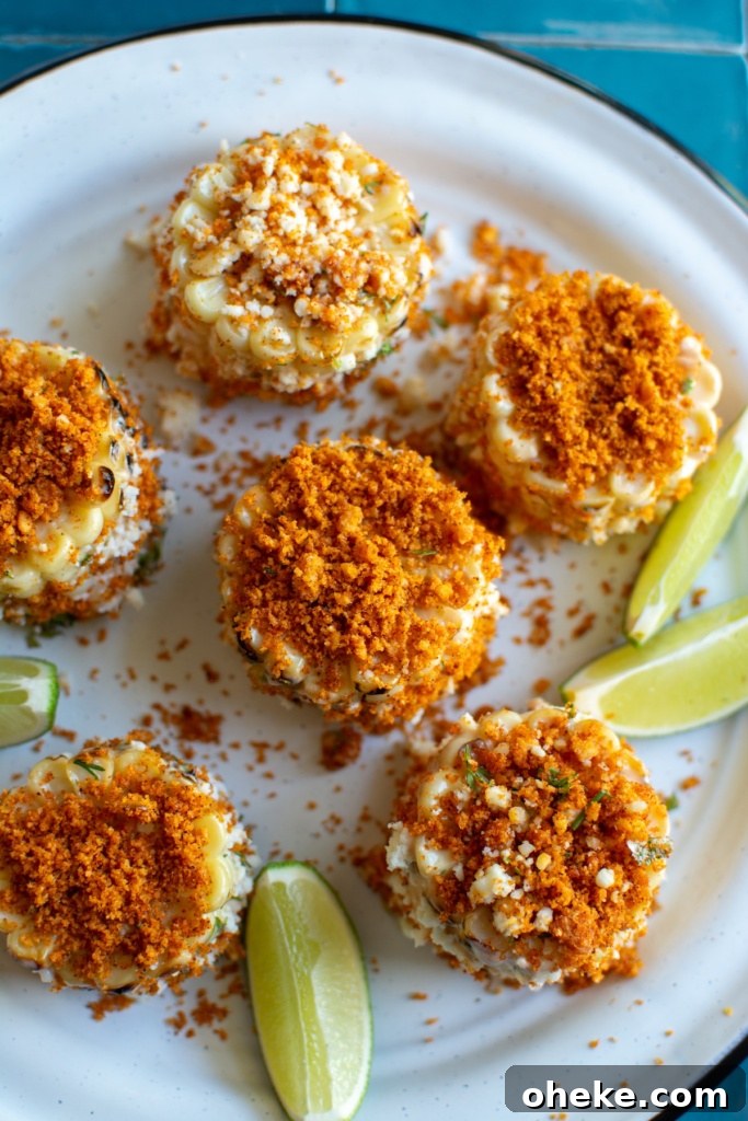 The elote cut into wheels with limes on a white plate