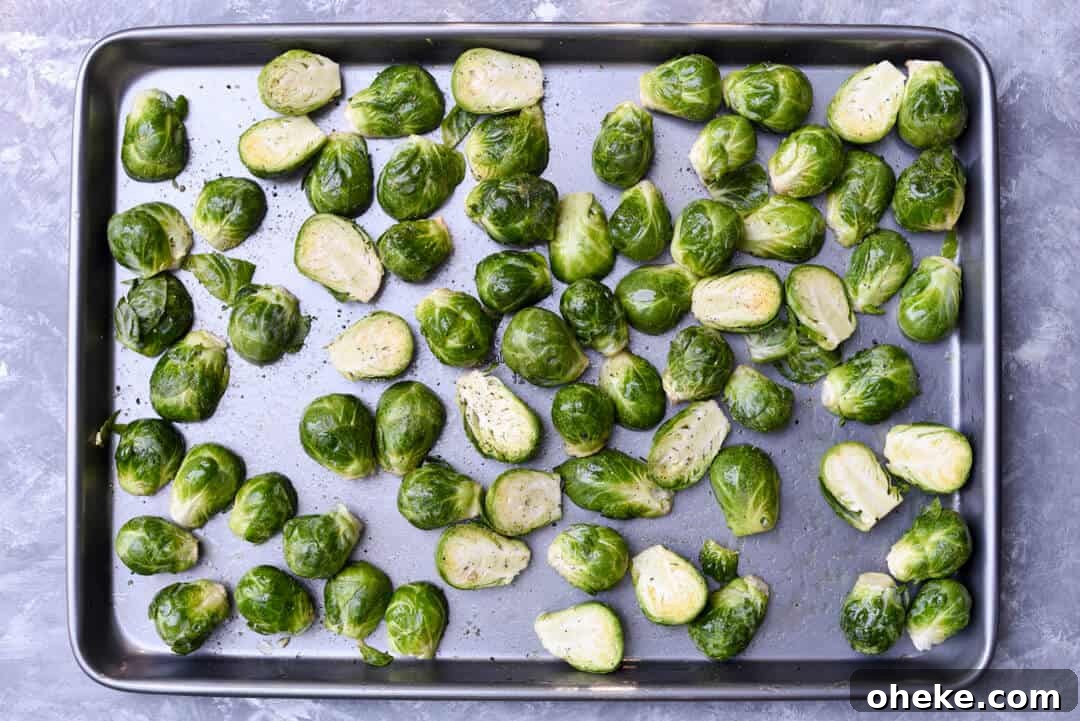 Halved Brussels sprouts on a rimmed baking sheet.