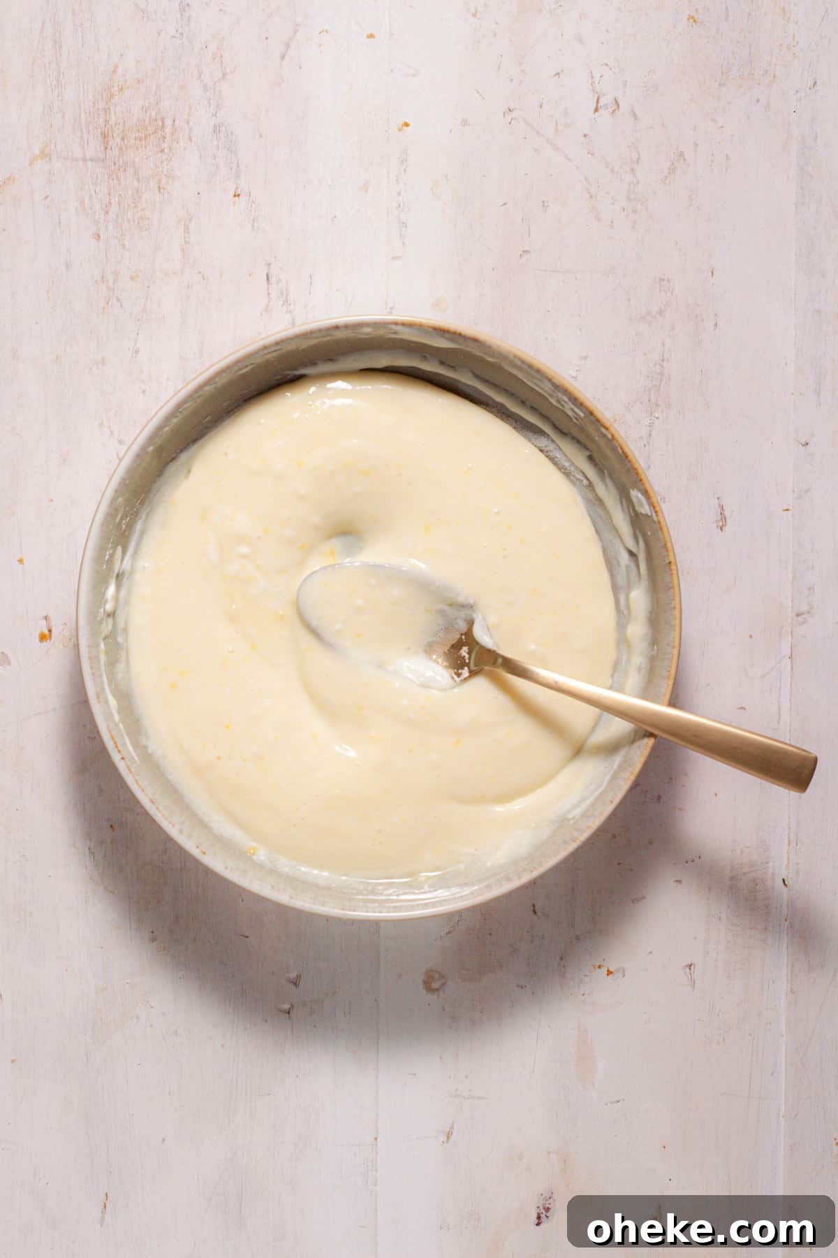A sour cream custard for mini peach pies in a medium bowl.