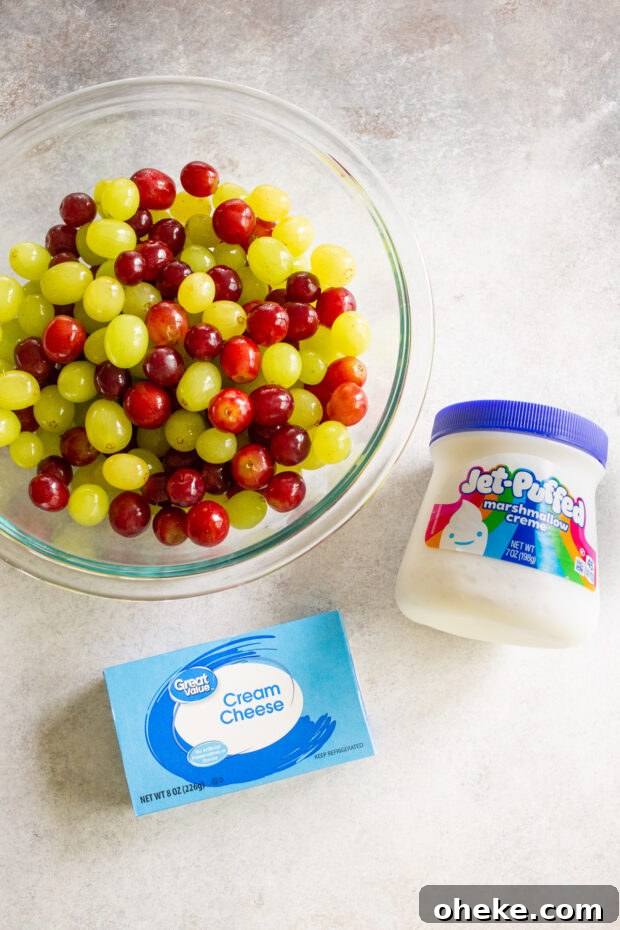 Grapes, cream cheese, and marshmallow creme on a table. 