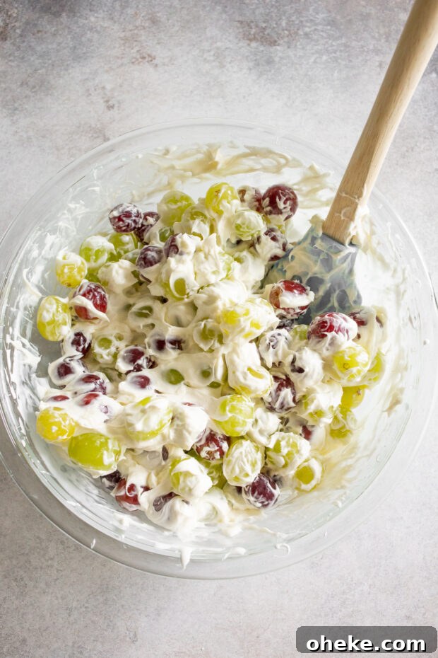 Grapes mixed with marshmallow fluff and cream cheese in a bowl. 