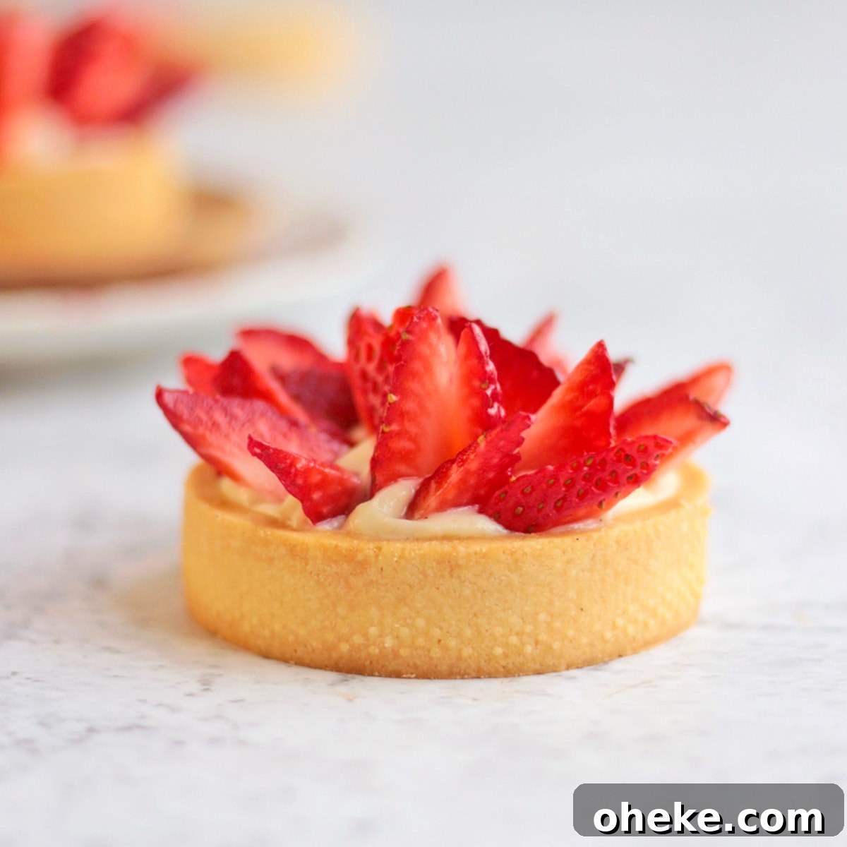 One Strawberry Tartlet on a grey surface