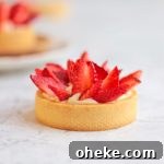 One Strawberry Tartlet over a grey surface