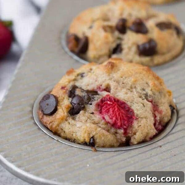 Moist Blueberry Bran Muffins with Honey and Cinnamon 12 Close-up image of a muffin flecked with fresh strawberries and gooey dark chocolate chips.