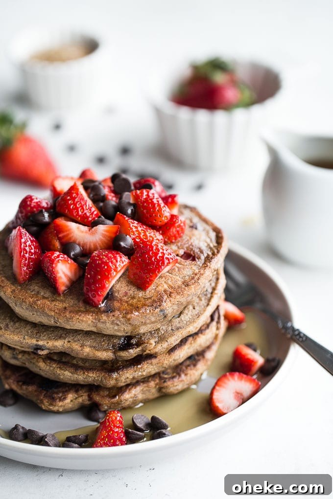 Strawberry Chocolate Chip Buckwheat Pancakes Recipe 2 Stack of Strawberry Chocolate Chip Buckwheat Pancakes on a grey plate.