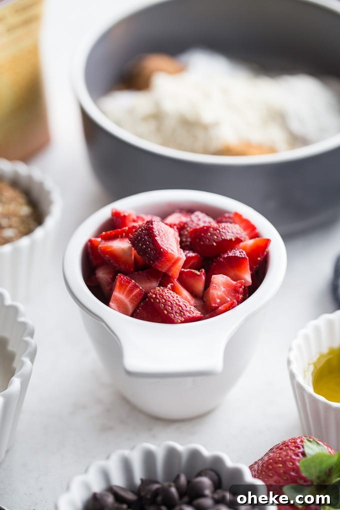 Strawberry Chocolate Chip Buckwheat Pancakes Recipe 3 Up-close view of chopped strawberries in a white cup.