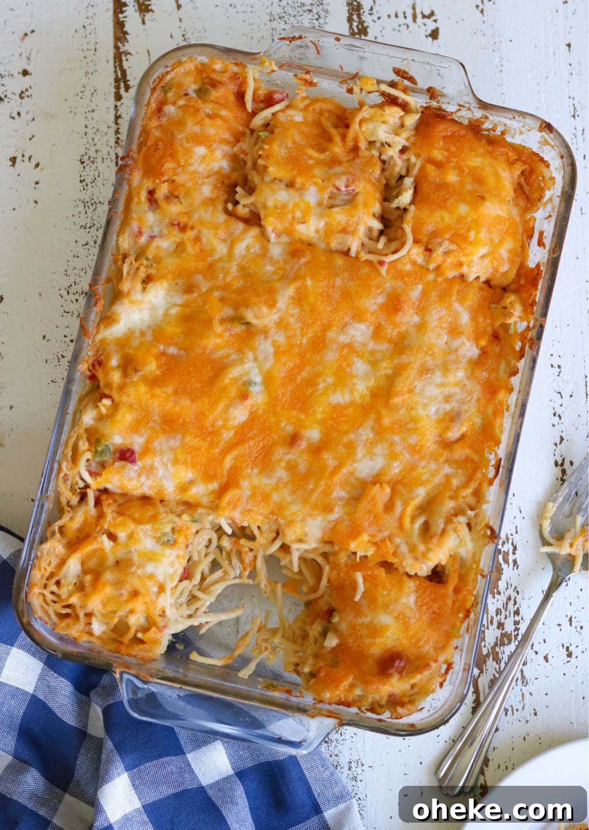 Southern Chicken Spaghetti with RoTel: Cheesy Tex-Mex Casserole 5 A baking dish with finished chicken spaghetti in it showing the top of the casserole - one serving is removed.