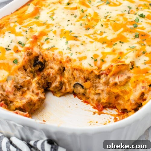 A dish of Mexican lasagna with a serving removed. Feature image.
