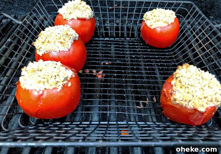 stuffed tomatoes in a grill basket on the grill