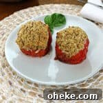 2 grilled stuffed tomatoes on a small white plate