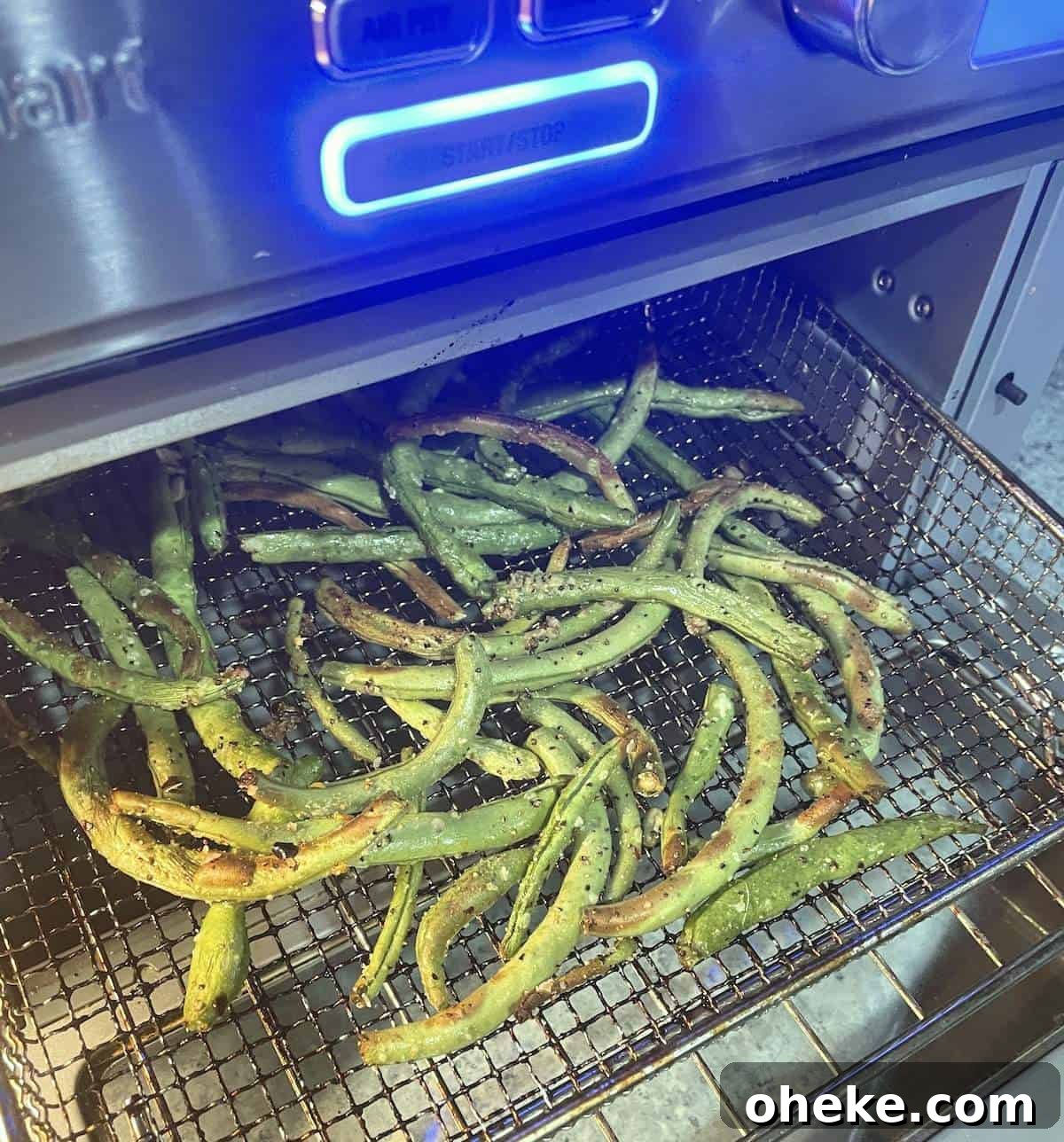 Crispy Garlic Air Fryer Green Beans_recipe 5 Air fried green beans in the basket of a Cuisinart air fryer.
