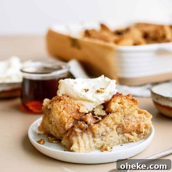 A slice of Brown Sugar and Maple Bread Pudding on a plate topped with whip cream.