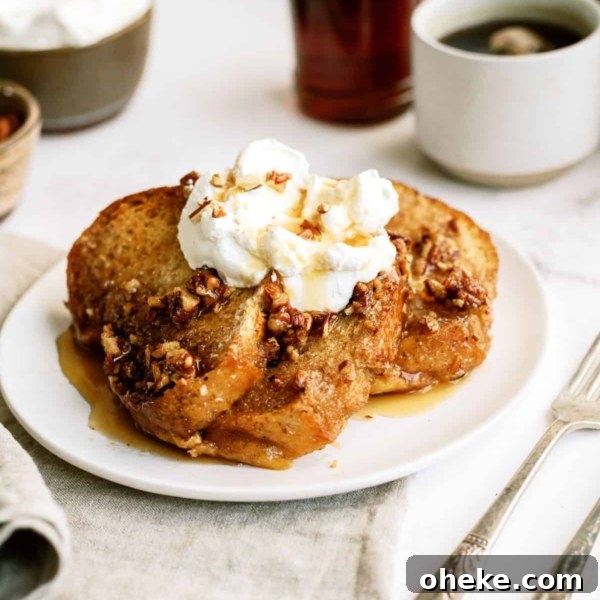 A slice of Overnight Pecan Praline Baked French Toast on a plate with whipped cream.