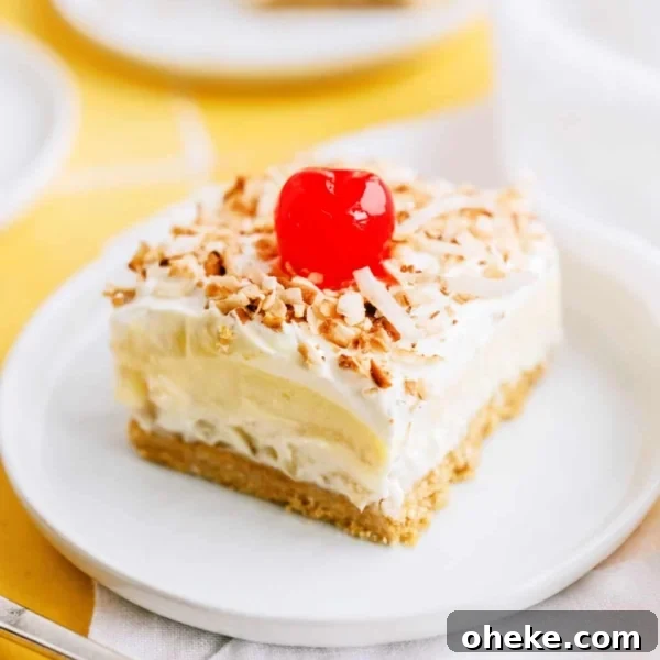 Layered pina colada dessert with cherry on a plate.