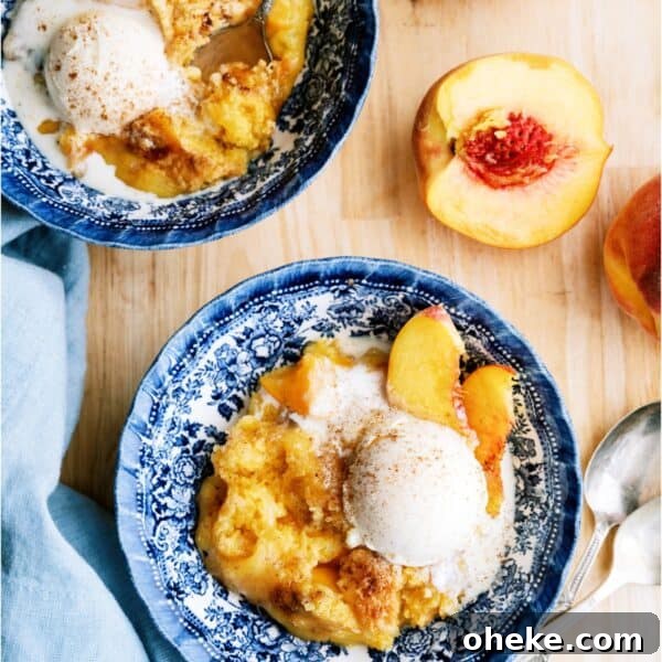 2 bowls of Peach Cobbler Dump Cake topped with ice cream. Fresh peaches cut in half.