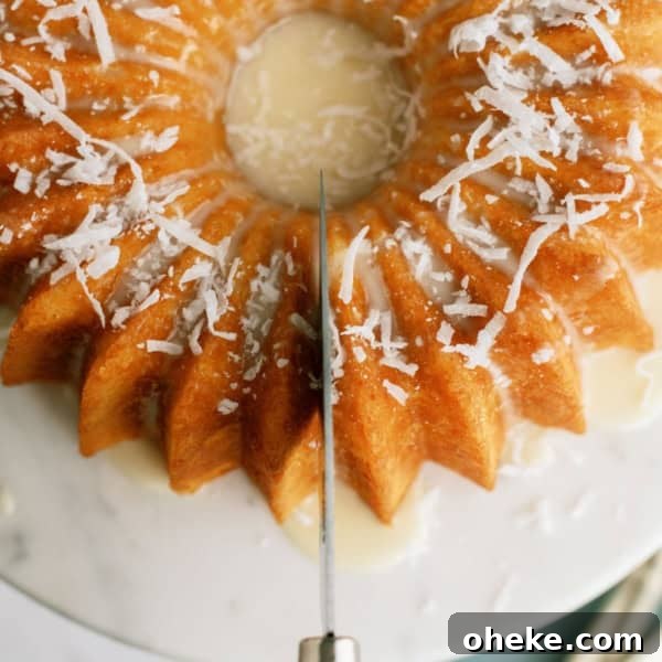 Top view of a knife cutting a slice of Pineapple Coconut Bundt Cake.