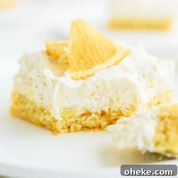 A slice of Pineapple Orange Cake on a plate with a section of the slice cut off.