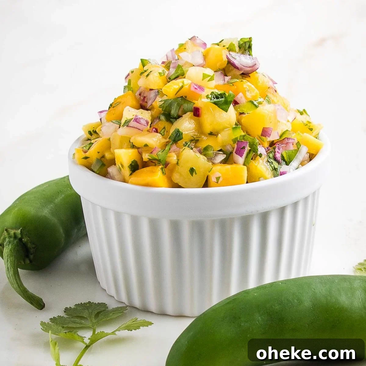Small white bowl piled high with pineapple mango salsa.