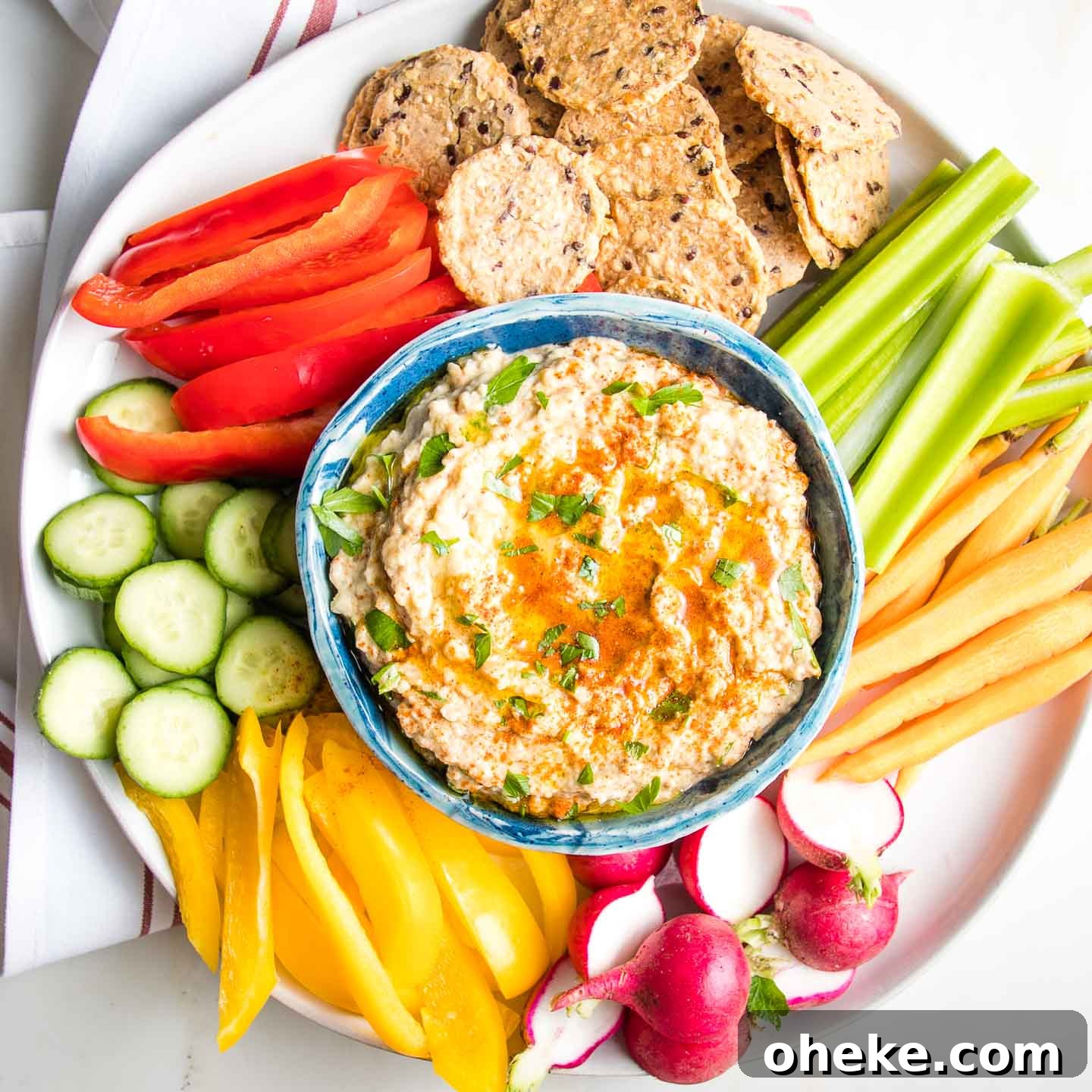 Blue bowl filled with Roasted Eggplant Dip sprinkled with parsley and paprika