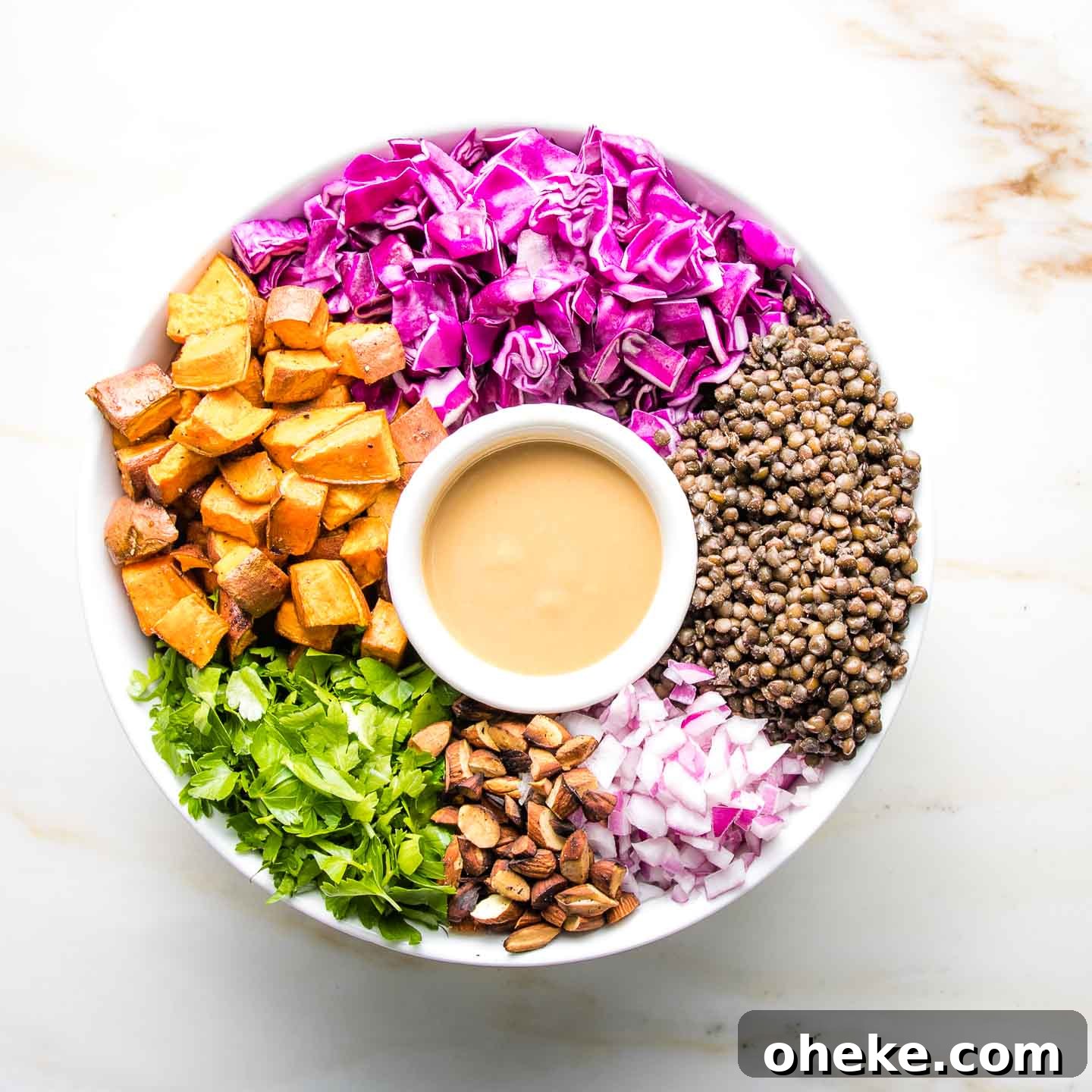 Vegan Lentil Salad with colorful ingredients arranged around a small dish of dressing.