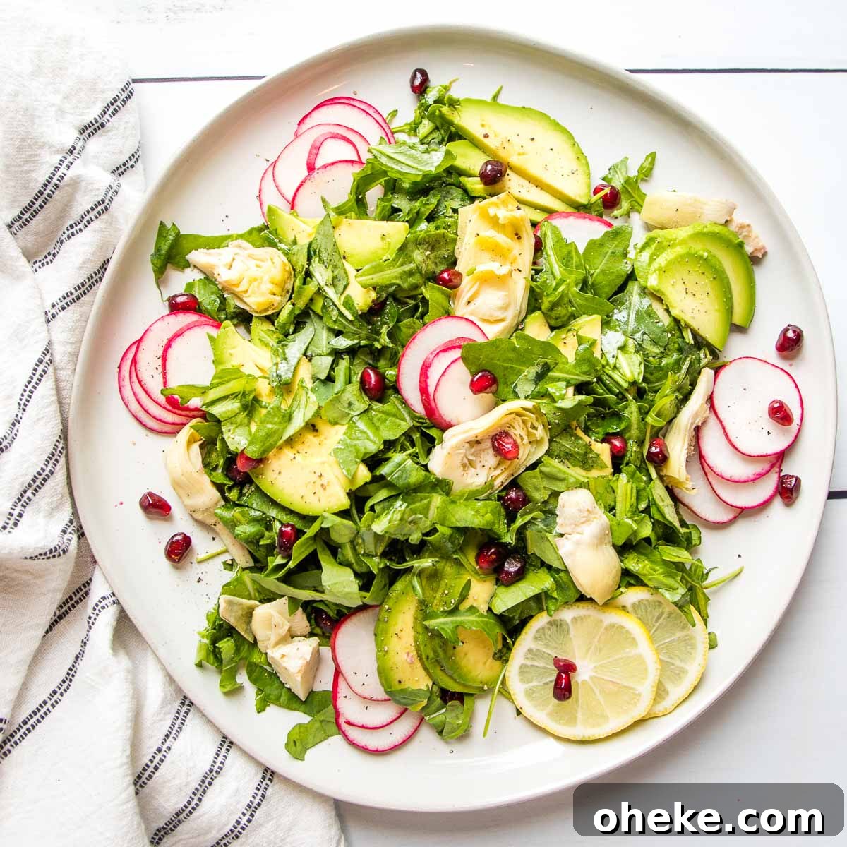 Large rimmed white plate with lemony arugula salad.