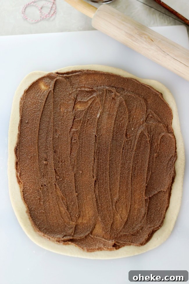 cinnamon roll dough rolled with butter and sugar and cinnamon spread