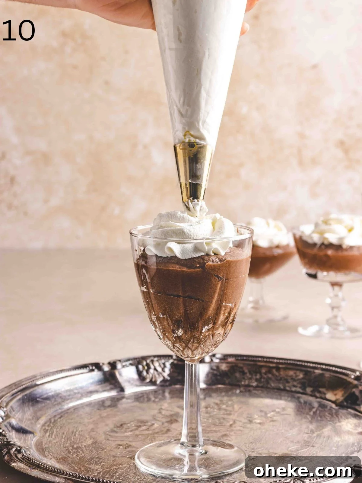 Piping whipped cream over chilled mousse de chocolat.