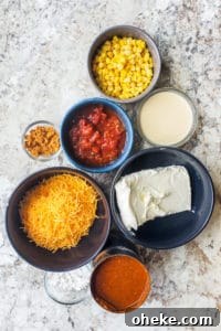 Chili cheese dip recipe ingredients in bowls on a white counter.