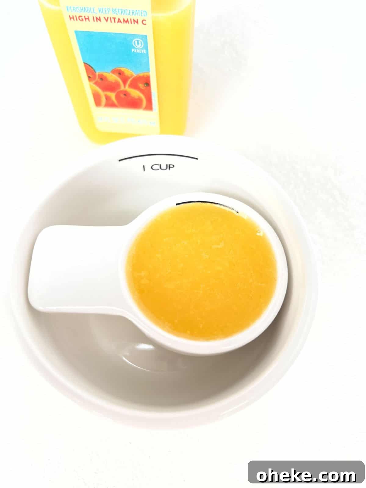 How Many Ounces Are in 1/4 Cup? 2 A quarter cup measuring cup filled with orange juice inside of a one cup measuring cup.