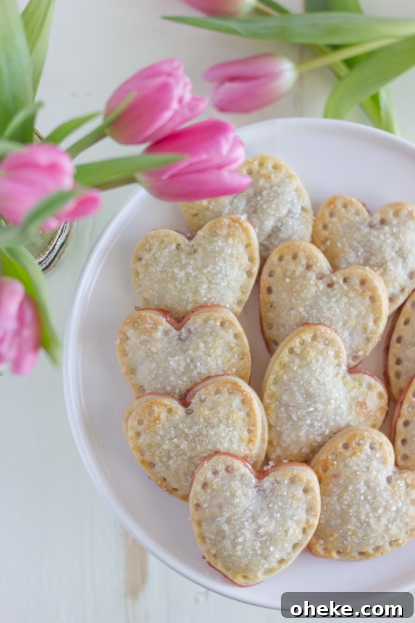 Strawberry Pie Hearts arranged on a cake stand, sitting next to some pink tulips.  