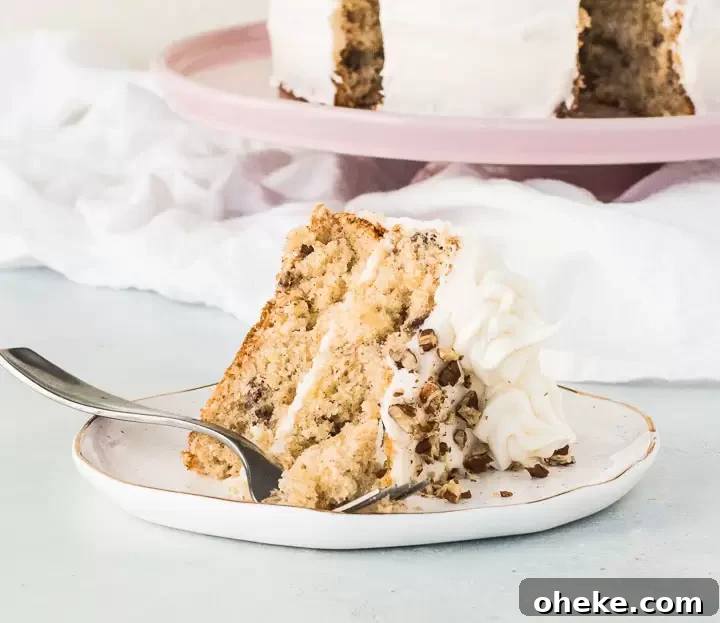 slice of hummingbird cake on a plate in front of a cake stand