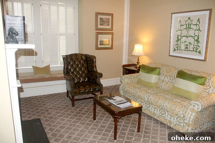 Visit Aiken, SC: Top Things to Do, Where to Stay, and Local Tips 8 Sitting room with a green patterned sofa and brown chair in the suite at The Willcox Hotel.
