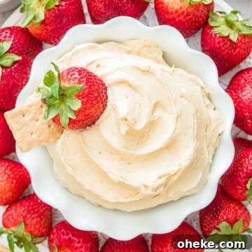 A bowl of creamy fluffernutter dip surrounded by fresh strawberries, graham crackers, and vanilla wafers for dipping.