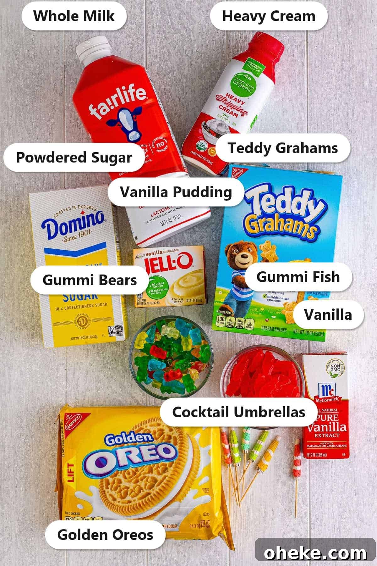 Chocolate Sand Pudding Cups Recipe for Kids' Parties 3 Labeled ingredients for sand pudding including golden Oreos, instant vanilla pudding, whole milk, heavy cream, powdered sugar, vanilla, and gummi candy garnishes.