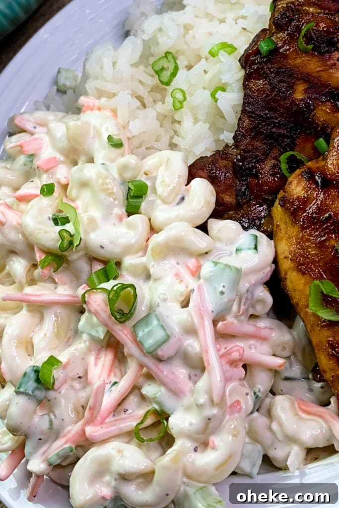 Close up of authentic Hawaiian macaroni salad on a white plate served with Huli Huli chicken.