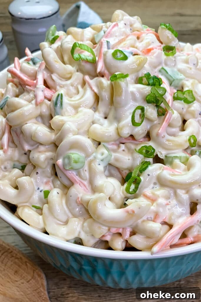 Authentic Hawaiian macaroni salad in a blue bowl and garnished with green onion.