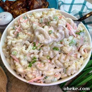 A spoon taking a scoop of Hawaiian macaroni salad frome a serving bowl.