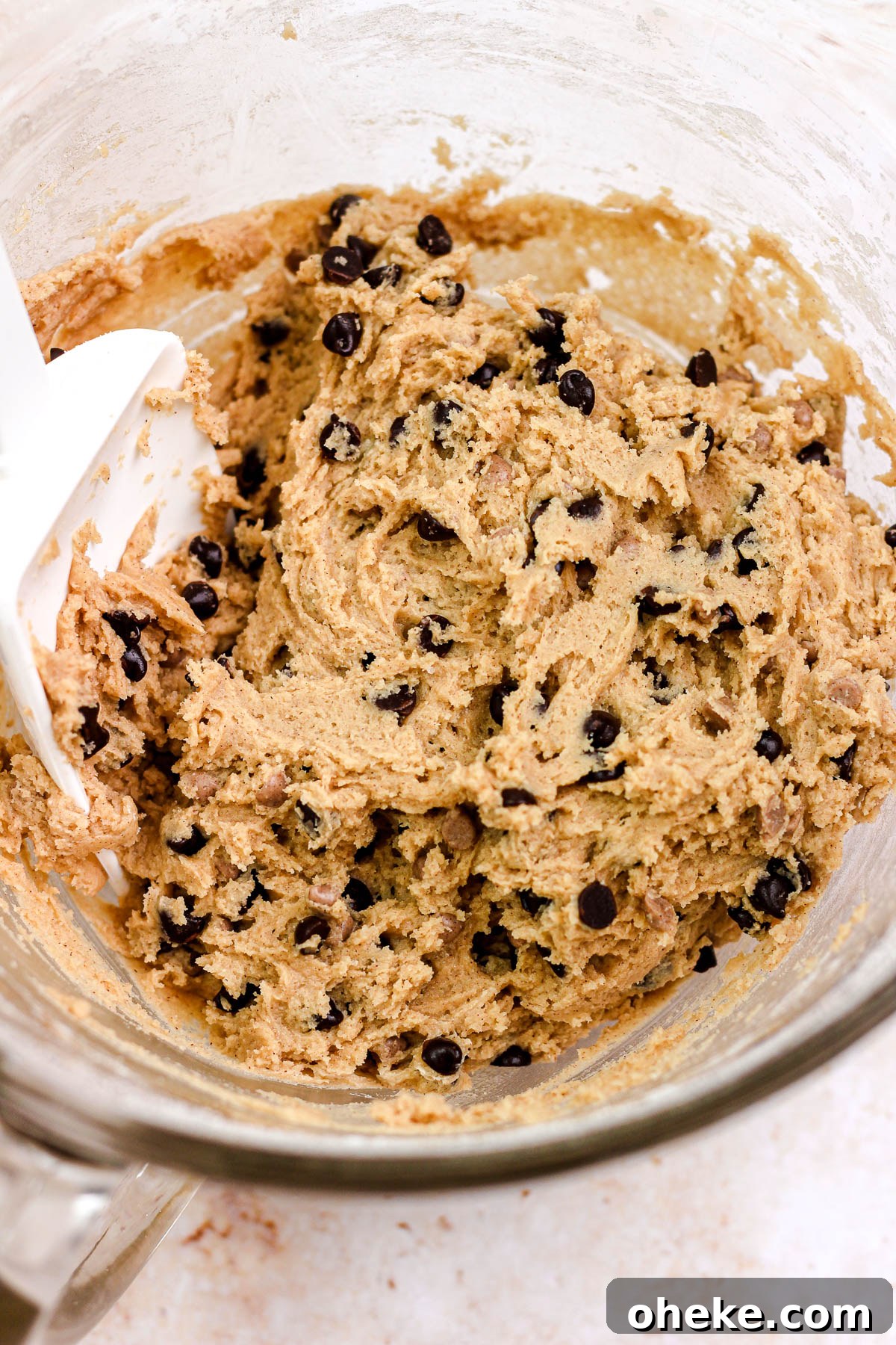 Cinnamon chocolate chip cookie dough in a glass bowl.