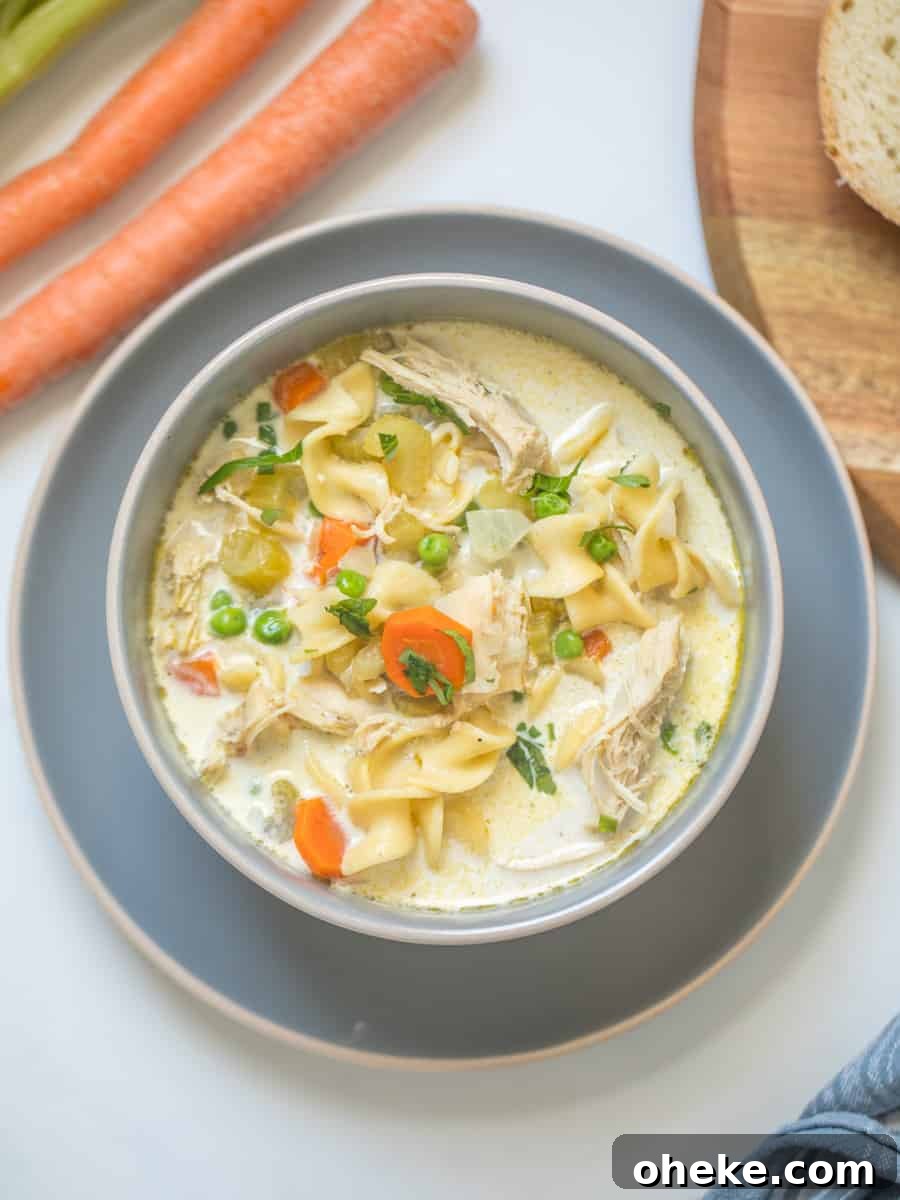 Bowl of Creamy Instant Pot Turkey Noodle Soup topped with fresh parsley made with egg noodles, carrots, peas, and leftover turkey.