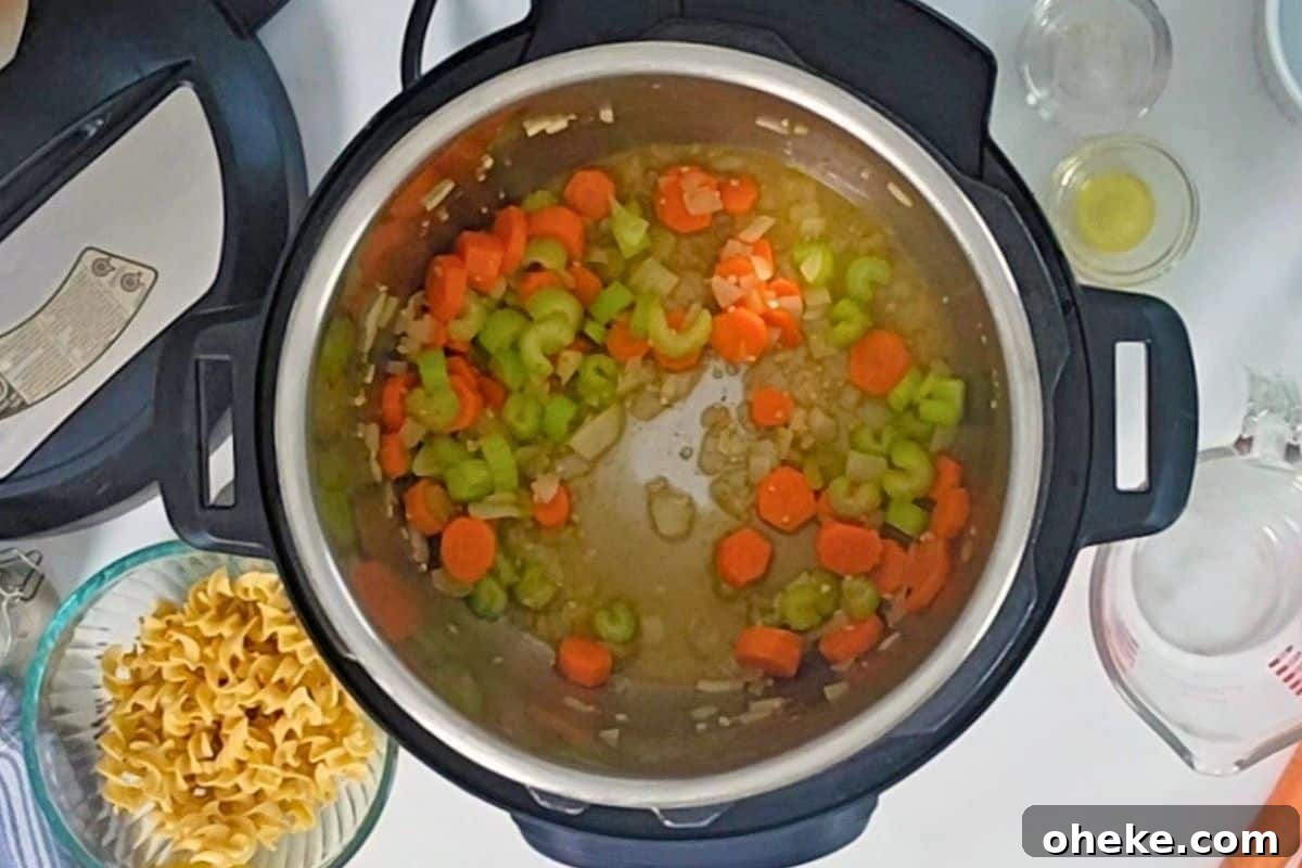 Inner pot after deglazing with white wine with carrots, onions, celery, and garlic sauteed in pressure cooker with olive oil and butter and ingredients for turkey noodle soup in background.