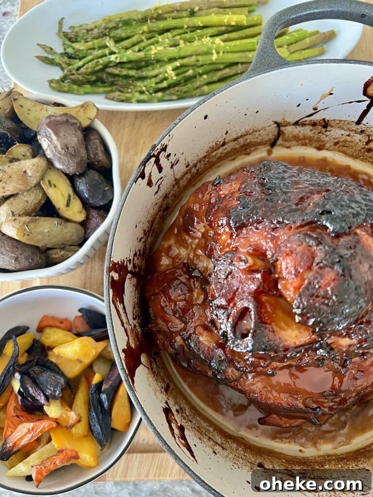 Dutch Oven Spiral Ham with Marsala Glaze Recipe 3 Glazed, baked ham in a Dutch oven shown with roasted asparagus, roasted rosemary potatoes and roasted rainbow carrots.